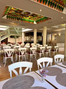 a restaurant with white tables and white chairs at Hotel Talisman in Ponta Delgada