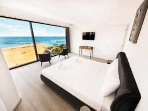 a bedroom with a bed and a view of the beach at Maritimo ApartHotel in Constanţa