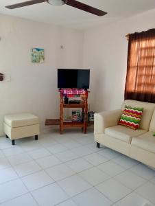 a living room with a couch and a tv at Cozy beachfront house Cocomar in San Crisanto