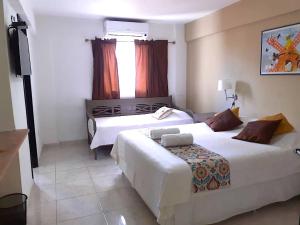 ein Hotelzimmer mit zwei Betten und einem Fenster in der Unterkunft Hotel Arthaus in Asunción