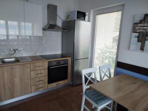a kitchen with a stainless steel refrigerator and a table at Apartment Hribar in Labin