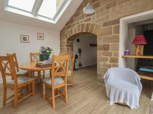 a dining room with a table and chairs and a brick wall at Shepherd's Crook in Harrogate