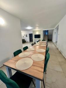 a large conference room with a long table and green chairs at Vila Safir MM in Şurdeşti