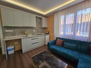 a living room with a blue couch and a kitchen at ESLA Suites in Çamlıhemşin
