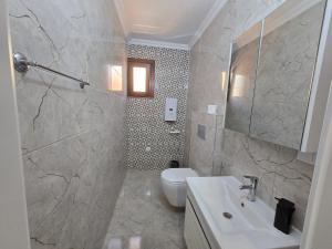 a bathroom with a white toilet and a sink at ESLA Suites in Çamlıhemşin +48 photos