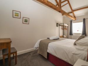 a bedroom with a bed and a desk and a window at Shepherd's Crook in Harrogate