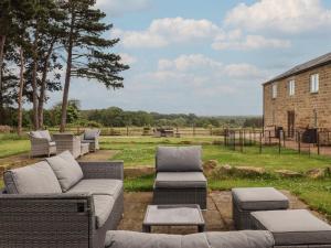 a patio with a couch and chairs and a building at Shepherd's Crook in Harrogate