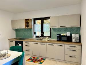 a kitchen with white cabinets and a counter top at Vila Safir MM in Şurdeşti