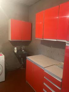 a red kitchen with a sink and red cabinets at Lake View Sioni in Sioni +9 photos