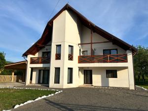 a large white house with a gambrel roof at Vila Safir MM in Şurdeşti