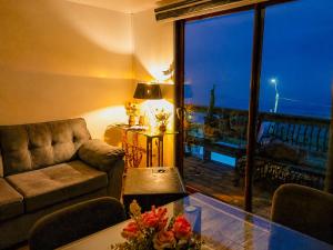 a living room with a couch and a large window at Cabaña el Sol in La Boca
