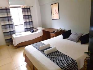 ein kleines Zimmer mit zwei Betten und einem Fenster in der Unterkunft Hotel Arthaus in Asunción