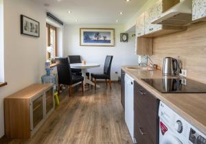 a kitchen and dining room with a table and chairs at Upes lillijas in Jelgava