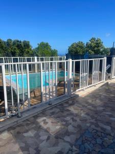 a white metal fence next to a swimming pool at Lacazavanoo in Baillif