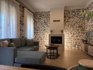 a living room with a couch and a fireplace at Amara Centro Luxury Apartments in Mouzaki