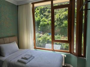 a bedroom with a bed and a large window at ESLA Suites in Çamlıhemşin