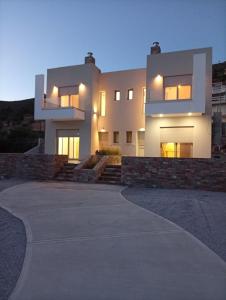 a large white house with a driveway at Almira Suites by the sea 3 in Áyios Dhimítrios