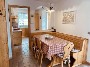 a kitchen with a table and chairs in a room at My sweet home in the Dolomites - Appartamento LatteMiele in Predazzo