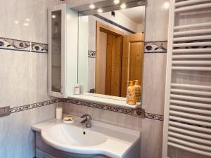 a bathroom with a sink and a mirror at My sweet home in the Dolomites - Appartamento LatteMiele in Predazzo +27 photos