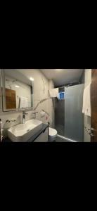 a bathroom with a sink and a toilet and a mirror at Hotel Boheme in Peje +53 photos