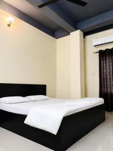 a large bed with white sheets and pillows on it at Moonleaf Stay, Guwahati in Guwahati