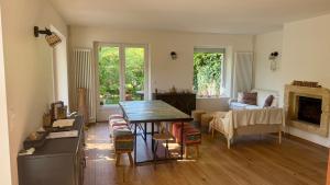 a living room with a table and chairs at L'Autre Paradis-Piscines naturelles-Plages-Jardin enchanté-Sauna in Poligny
