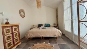 a bedroom with a bed and a large window at L'Autre Paradis-Piscines naturelles-Plages-Jardin enchanté-Sauna in Poligny