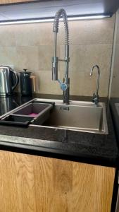 a sink in a kitchen with a faucet at L'Autre Paradis-Piscines naturelles-Plages-Jardin enchanté-Sauna in Poligny