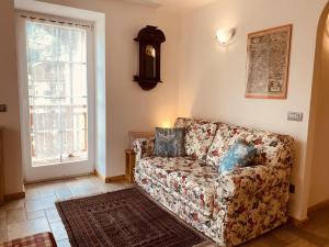 a living room with a couch and a window at My sweet home in the Dolomites - Appartamento LatteMiele in Predazzo
