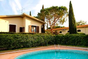 a swimming pool in front of a house at Appartamenti Il Granaio in Marina di Grosseto