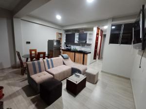a living room with a couch and a kitchen at Casa Sol in Tingo María
