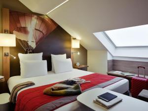 a bedroom with a large bed with a skylight at Mercure Vienne Sud Chanas in Chanas +82 photos