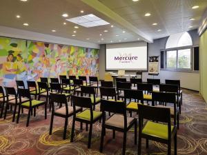 a conference room with chairs and a projection screen at Mercure Vienne Sud Chanas in Chanas
