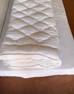 an unmade bed with white sheets on it at Jaaz Heights in Tāl