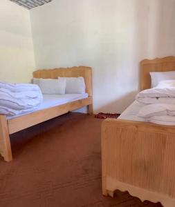 a room with two beds and twounks in it at Jaaz Heights in Tāl