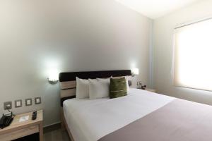 a bedroom with a large white bed and a window at Hotel EJM PREMIUM in Irapuato +30 photos