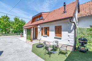a small white house with chairs and a table at House Majda in Zagreb