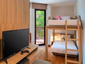 a living room with two bunk beds and a flat screen tv at Ibis Phuket Patong in Patong Beach