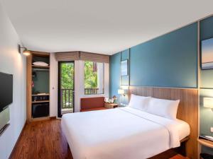a bedroom with a large white bed and a window at Ibis Phuket Patong in Patong Beach
