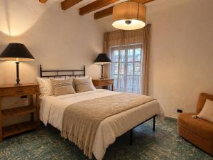 a bedroom with a bed and a chair and a window at Casas Balcón Gto in Guanajuato