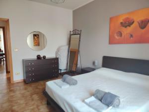 a bedroom with a bed and a dresser and a mirror at Appartamento Laura in Quargnento
