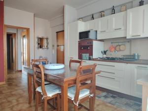 a kitchen with a wooden table and chairs in a room at Appartamento Laura in Quargnento