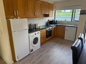 a kitchen with a white refrigerator and a dishwasher at Large four bedroom town centre house in Killarney