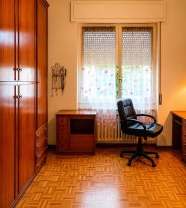 a room with a chair and a desk and a window at Room between Milan and Como in Seregno