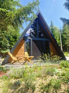 eine Blockhütte mit Veranda und Bank in der Unterkunft Pineta in Nišići