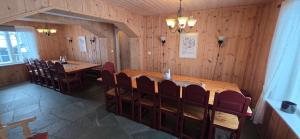 a dining room with a large wooden table and chairs at Lauvåsen Rooms Langleiken in Sør-Fron