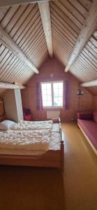 a attic room with a bed and two windows at Lauvåsen Rooms Langleiken in Sør-Fron