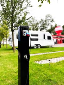 a black post in the grass next to a rv at SCANDINAVIA Camping in Zator