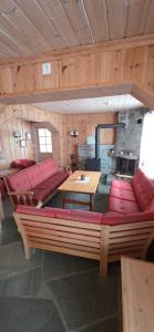 a living room with red couches and a table at Lauvåsen Rooms Langleiken in Sør-Fron