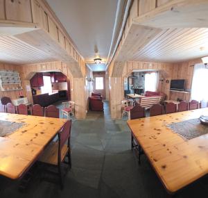 a dining room with wooden tables and chairs at Lauvåsen Rooms Langleiken in Sør-Fron